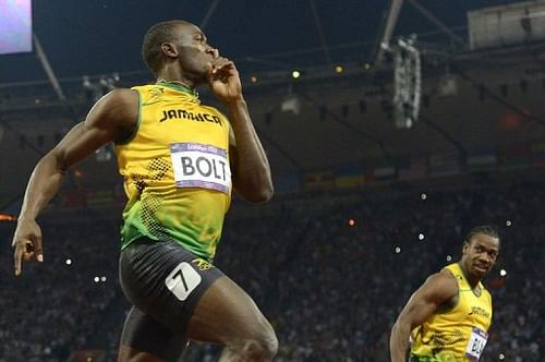 Jamaica's Usain Bolt (C) looks at Yohan Blake (R) as he crosses the finish line to win the men's 200m final