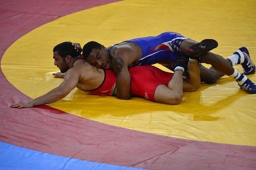 Iran&#039;s Sadegh Goudarzi (L) wrestles USA&#039;s Jordan Burroughs
