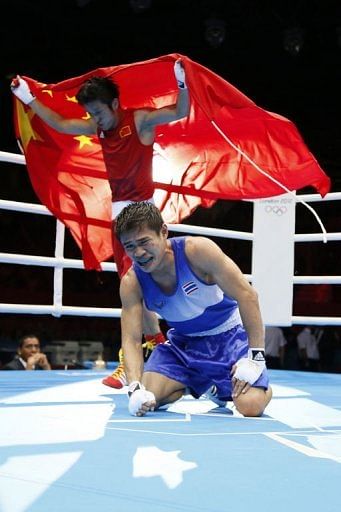 Kaeo Pongprayoon of Thailand (in blue) reacts as Zou Shiming of China (in red) is declared the winner
