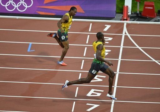 Jamaica&rsquo;s Usain Bolt looks across at teammate Yohan Blake as he beats him to the finish line to take gold in the 200m