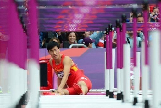 Liu Xiang wears a look of grim determination moments before climbing back to his feet in the 100m hurdles heats