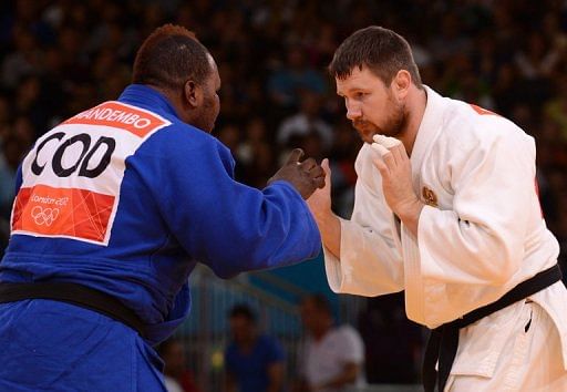 Russia&#039;s Alexander Mikhaylin (white) competes with DR Congo&#039;s Cedric Mandembo Kebika (blue) on August 3