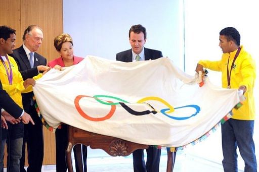 Brazilian President Dilma Rousseff (C) and others pose with the Olympic flag