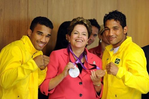 Brazilian President Dilma Rousseff (C) poses with Olympic boxers Yamaguchi Falcao (R) and Esquiva Falcao (L)