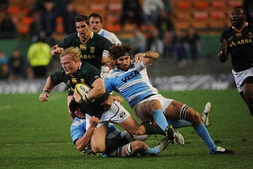 South Africa&#039;s Adriaan Strauss (L) fights off Argentina&#039;s Juan Lobbe (R)
