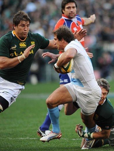 Argentina&#039;s Gonzalo Camacho (C) runs with the ball from South Africa&#039;s Willem Alberts (L) and Jean de Villiers