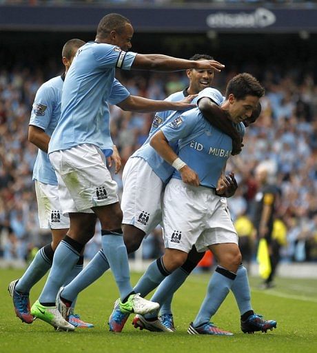 Manchester City&#039;s French player Samir Nasri (R) celebrates with teammates after scoring a goal