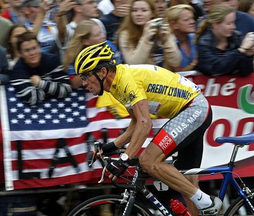 Armstrongrides as supporters waving the American flag cheer him on during the last stage of the 90th Tour de France