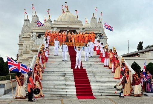 Torchbearers pose with the Paralympic flame outside the Shri Swaminarayan Mandir Temple in London