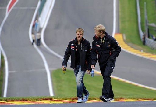 Red Bull Racing&#039;s German driver Sebastian Vettel (L) walks the track