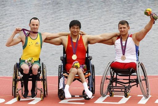 China&#039;s Cheng Huang (C) celebrates winning the gold medal in the AS men single sculls
