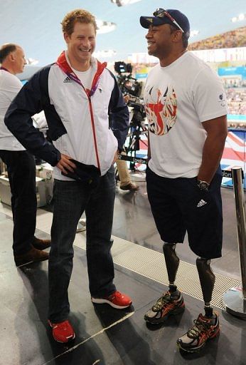 Britain's Prince Harry (L) talks with former British soldier and Paralympic athlete Derek Derenalagi