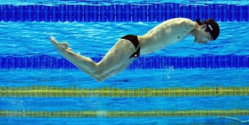 A Chinese swimmer is seen through an underwater window during a practice session