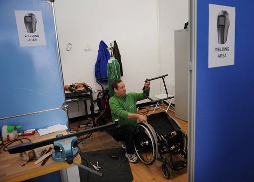 A technician works on a wheelchair belonging to an athlete competing in the London 2012 Paralympic Games