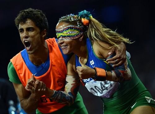 Brazil's Terezinha Guilhermina (right) and guide Guilherme Soares de Santana celebrate after winning the 100m T11 final