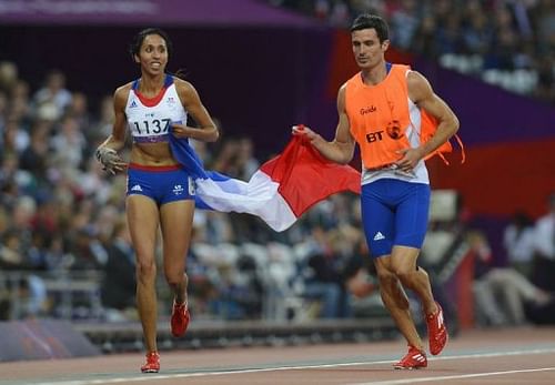 France's Assia El Hannouni (L) and her guide Gautier Simounet (R) celebrate winning the gold medal