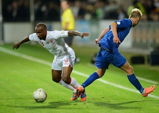 Jermain Defoe (L) of England fights for the ball with Suvorov Alexandru of Moldova