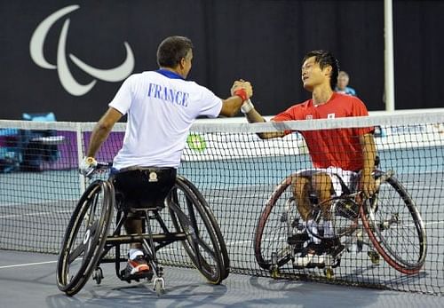 Japan's Shingo Kuneida (R) shakes hands with France's Stephane Houdet