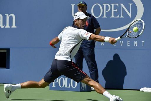 Novak Djokovic of Serbia returns against  David Ferrer of Spain