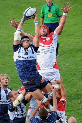Castres&#039; lock Christophe Samson (L) grabs the ball in a line-out despite Biarritz&#039;s lock Jerome Thion