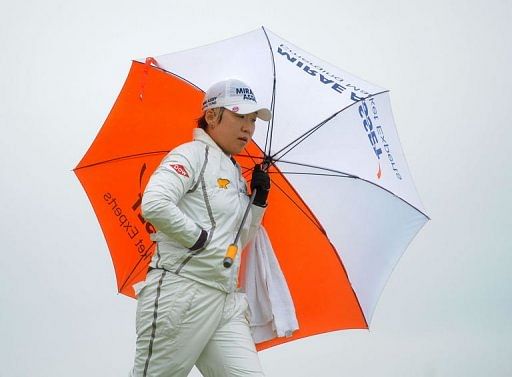 Shin Jiyai of Korea holds an umbrella during the final round of the Women&#039;s British Open golf tournament