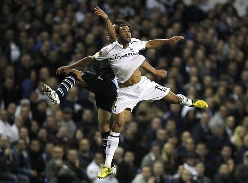 Lazio&#039;s Cristian Ledesma (L) jumps for the ball with Tottenham Hotspur&#039;s Moussa Dembele