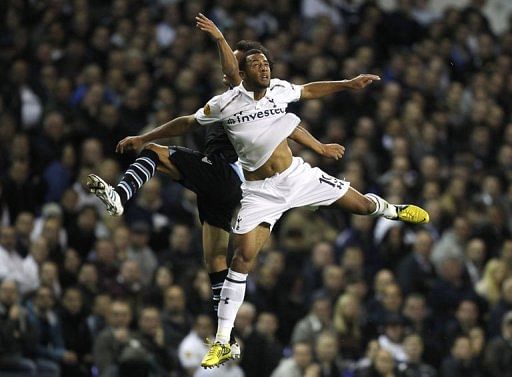 Lazio's Cristian Ledesma (L) jumps for the ball with Tottenham Hotspur's Moussa Dembele