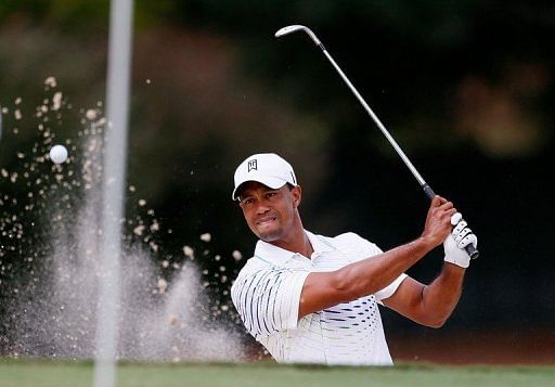 Tiger Woods play a bunker shot on the fourth hole