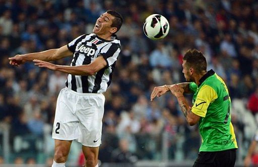 Juventus&#039; defender Lucio (L) jumps for the ball over Chievo&#039;s forward Cyril Thereau