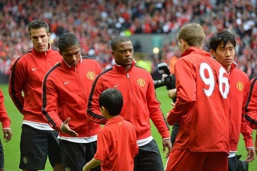 Manchester United defender Patrice Evra (3rd L) waits to shakes hands with Liverpool&#039;s Steven Gerrard (2nd right)