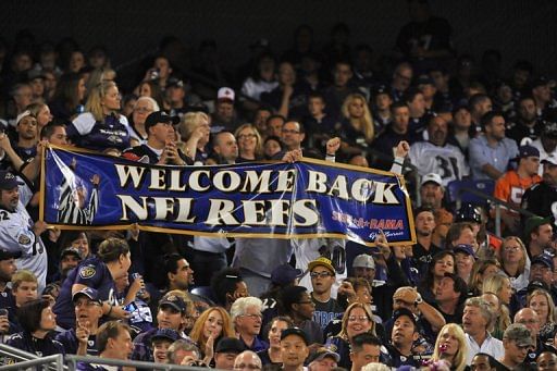 Baltimore Ravens fans cheer the return of regular referees