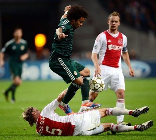Real Madrid&#039;s Marcelo (C) jumps over Ajax Amsterdam&#039;s Christian Poulsen