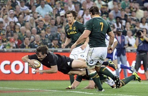 New Zealand&#039;s Conrad Smith scores a try between South Africa&#039;s players Zane Kirchner (L) and Willem Alberts
