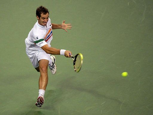 Richard Gasquet of France hits a return against Brian Baker of the US