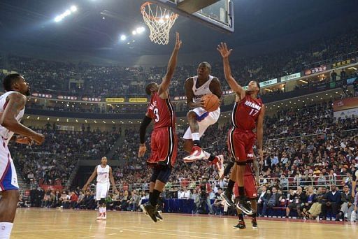 Jamal Crawford (C) of the Los Angeles Clippers jumps for the basket against Dwayne Wade of the Miami Heat