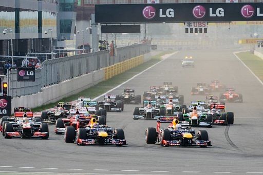 Sebastian Vettel of Germany (R) leads the pack at the start