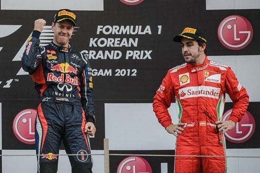 Sebastian Vettel (left) celebrates his victory on the podium next to Spanish driver Fernando Alonso