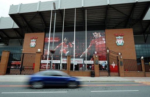 A car drives past photos of Liverpool footballers at the entrance of Liverpool FC&#039;s Anfield Stadium in Liverpool