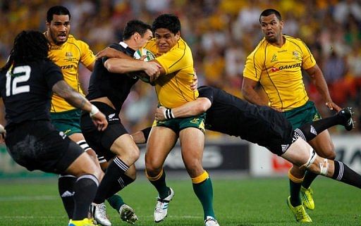 Australia&#039;s Ben Tapuai is tackled by Daniel Carter (left) and Richie McCaw (right) of New Zealand
