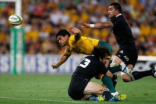 Australia&#039;s Ben Tapuai (yellow shirt) is tackled by Conrad Smith (bottom)