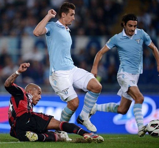 AC Milan&#039;s midfielder Nigel de Jong (L) slides to score against Lazio
