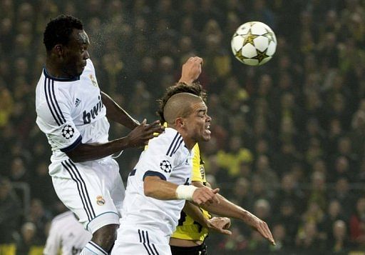 Real Madrid&#039;s Michael Essien (L) rises above teammate Pepe (C) and Dortmund&#039;s Mats Hummels for a header
