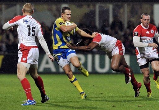 Clermont&#039;s fullback Lee Byrne (2ndL) is tackled by a Biarritz player