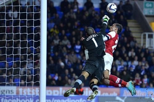 Reading's goalkeeper Adam Federici (L) clears the ball under pressure from Arsenal's Marouane Chamakh Reading's goalkeeper Adam Federici (L) clears the ball under pressure from Arsenal's Marouane Chamakh