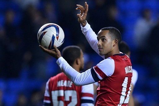 Arsenal striker Theo Walcott holds up the ball after scoring a hat-trick against Reading