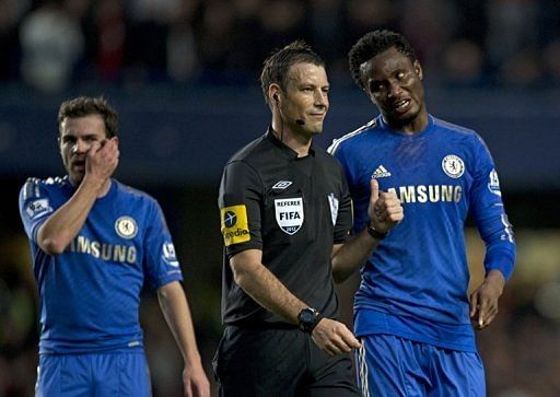 Chelsea&#039;s John Obi Mikel (R) talks with referee Mark Clattenburg