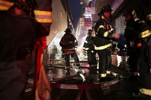 Firefighters work on an early morning storm-related fire in Brooklyn