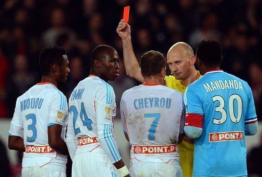 Marseille&#039;s Rod Fanni (2nd L) is given a red card by referee Antony Gautier