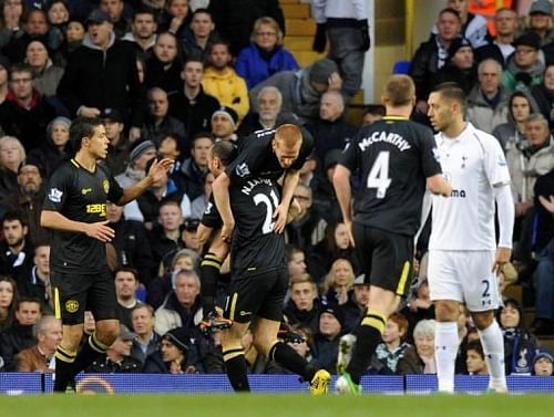 Wigan Athletic's midfielder Ben Watson (3rd L) is lifted by defender Ivan Ramis (2nd L) while celebrating his goal