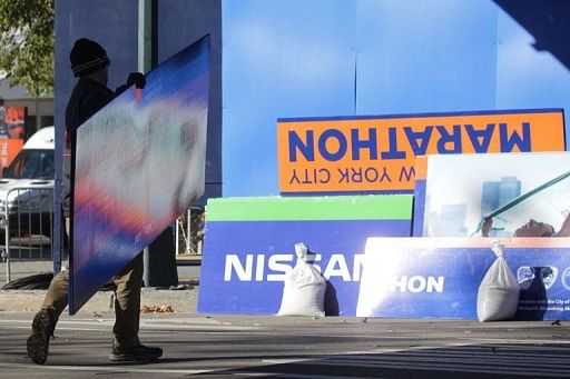 Workers take down signs at the finish line of the New York City Marathon